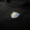 close up of embroidered shield logo on black oversized t-shirt premium cotton fabric