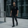 man wearing black oversized t-shirt with minimal logo modern streetwear style